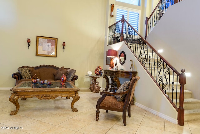 living area with a high ceiling and light tile patterned flooring