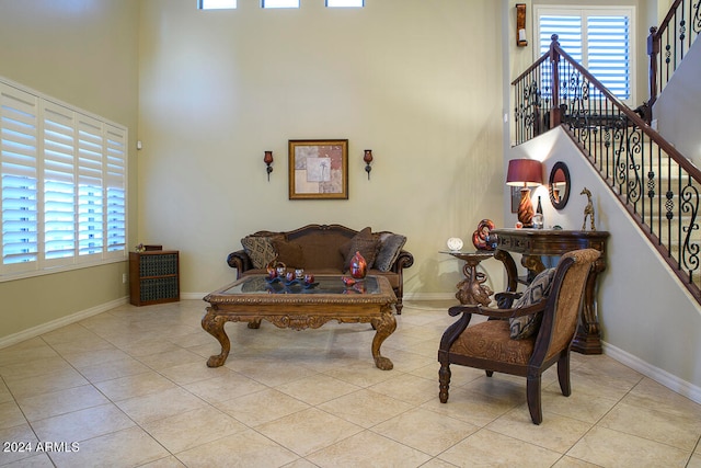 sitting room with light tile patterned floors and a towering ceiling