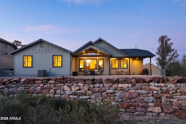 back house at dusk with central AC and a patio area