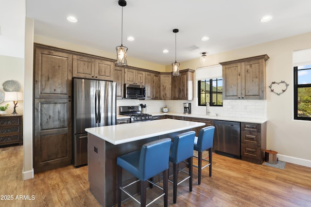 kitchen featuring a kitchen island, tasteful backsplash, appliances with stainless steel finishes, and a healthy amount of sunlight