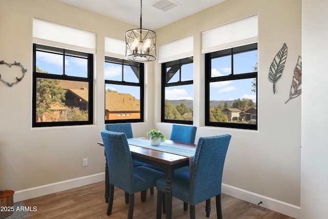 dining room with hardwood / wood-style floors and a chandelier