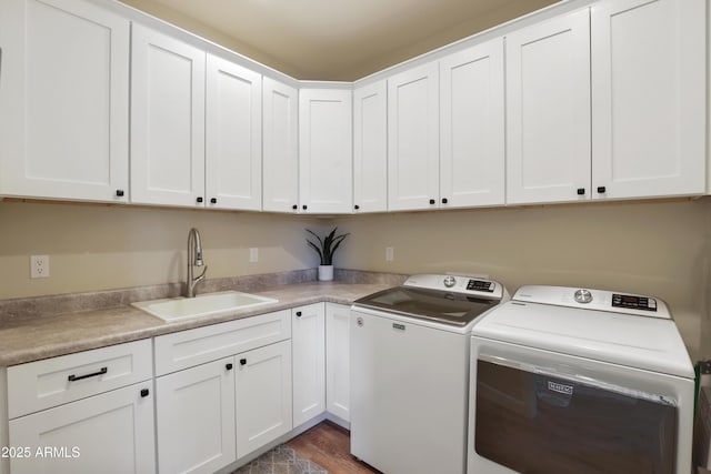 laundry room featuring cabinets, sink, washing machine and clothes dryer, and dark hardwood / wood-style flooring