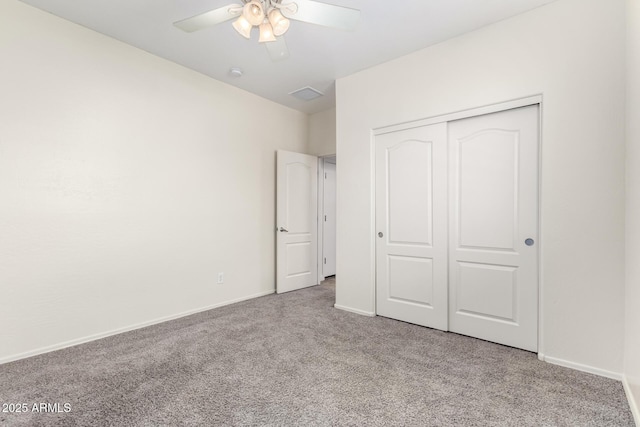 unfurnished bedroom with light colored carpet, a closet, and ceiling fan