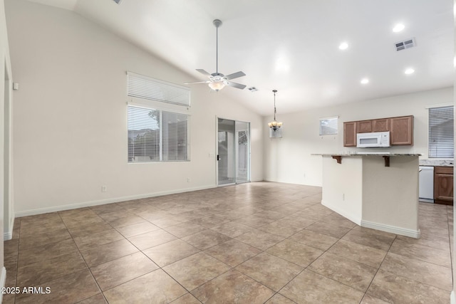 kitchen with a breakfast bar, white appliances, vaulted ceiling, and ceiling fan