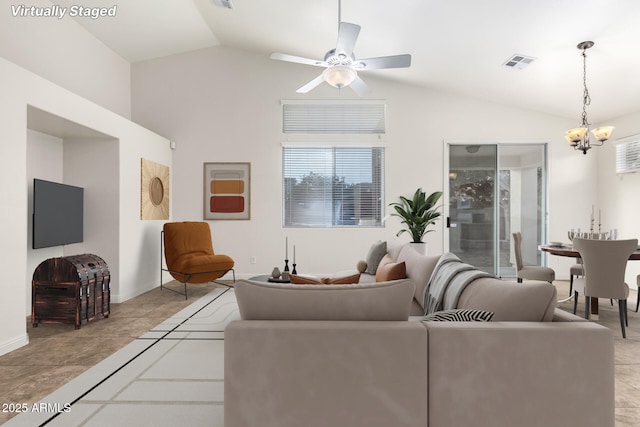 living room with ceiling fan with notable chandelier, light tile patterned flooring, and lofted ceiling