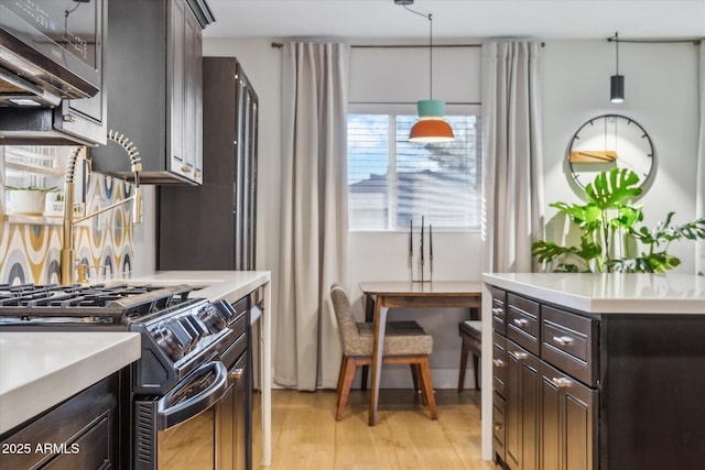 kitchen featuring stainless steel appliances, dark brown cabinetry, decorative backsplash, and hanging light fixtures