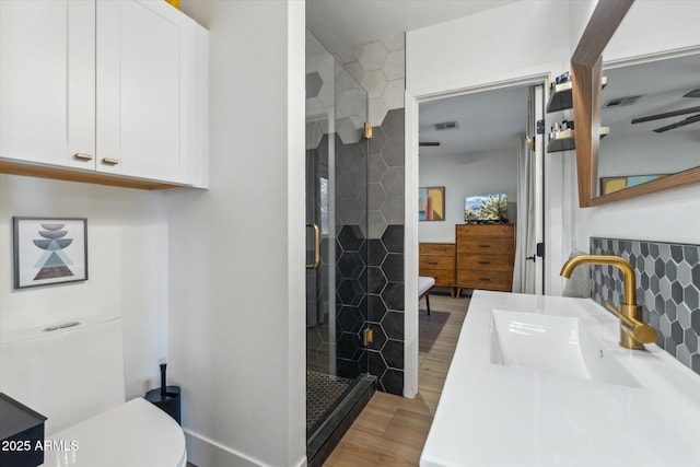 bathroom with vanity, a shower with shower door, and toilet