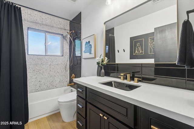 full bathroom featuring toilet, tasteful backsplash, shower / tub combo, wood-type flooring, and vanity