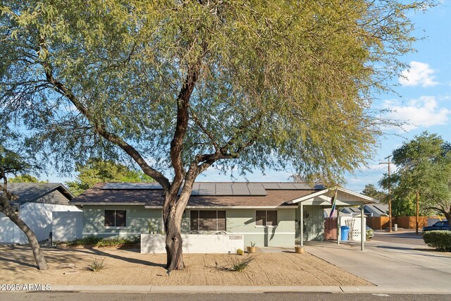 single story home featuring solar panels