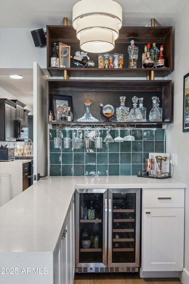 bar with white cabinets, backsplash, and wine cooler