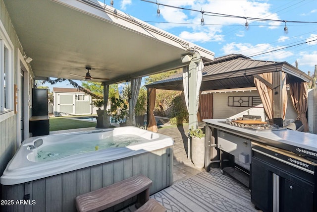 wooden terrace with a hot tub, a shed, and a gazebo