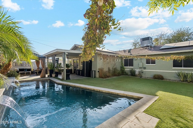 exterior space featuring a patio area, central air condition unit, pool water feature, and a yard