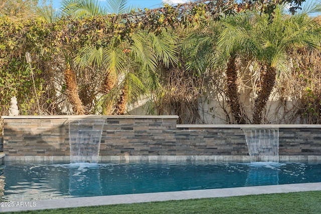 view of swimming pool with pool water feature