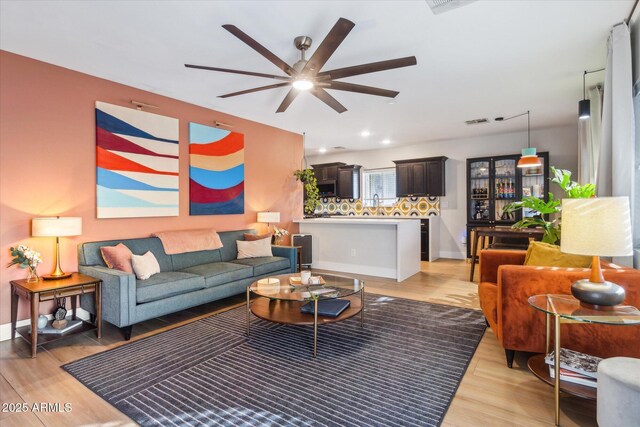 living room featuring light hardwood / wood-style floors and ceiling fan