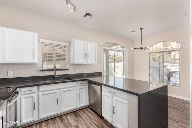 kitchen featuring white cabinetry, appliances with stainless steel finishes, sink, and decorative light fixtures