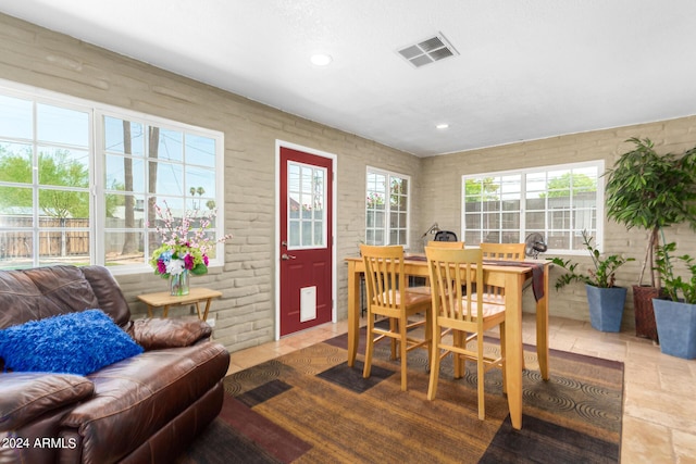 dining room featuring brick wall, plenty of natural light, visible vents, and recessed lighting