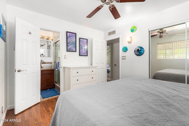 bedroom featuring visible vents, a ceiling fan, dark wood-type flooring, a sink, and a closet