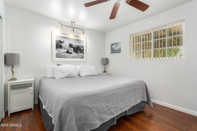 bedroom with dark wood-type flooring, ceiling fan, and baseboards