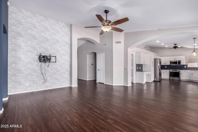 8500 W Saint John Rd, Peoria, AZ 85382 - unfurnished living room with a ceiling fan, brick wall, dark wood-type flooring, and baseboards