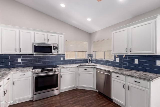 8500 W Saint John Rd, Peoria, AZ 85382 - kitchen with appliances with stainless steel finishes, a sink, vaulted ceiling, white cabinetry, and decorative backsplash