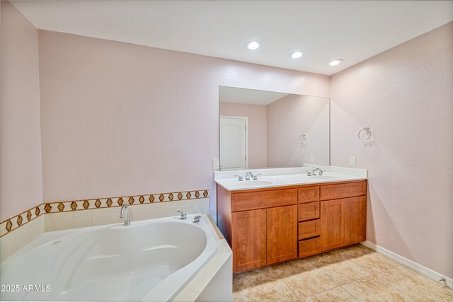 bathroom with a relaxing tiled tub, tile patterned flooring, and vanity