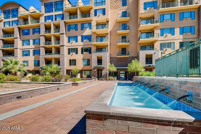 view of swimming pool with a jacuzzi and pool water feature