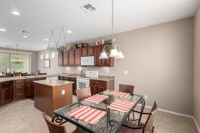 kitchen with a chandelier, visible vents, white appliances, and light countertops