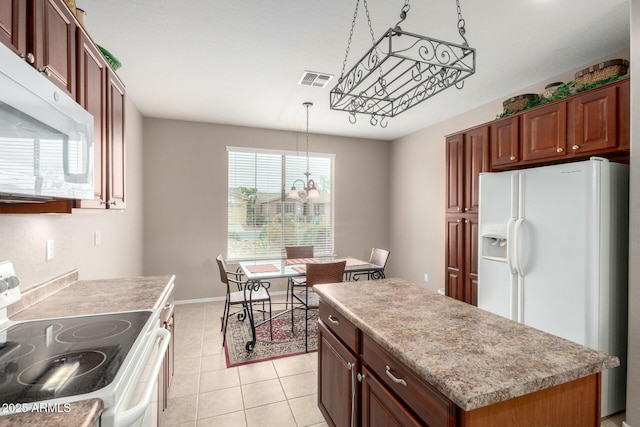 kitchen with visible vents, pendant lighting, light countertops, light tile patterned floors, and white appliances