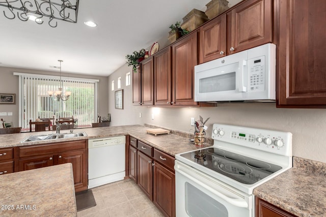 kitchen featuring pendant lighting, a sink, white appliances, light countertops, and a chandelier