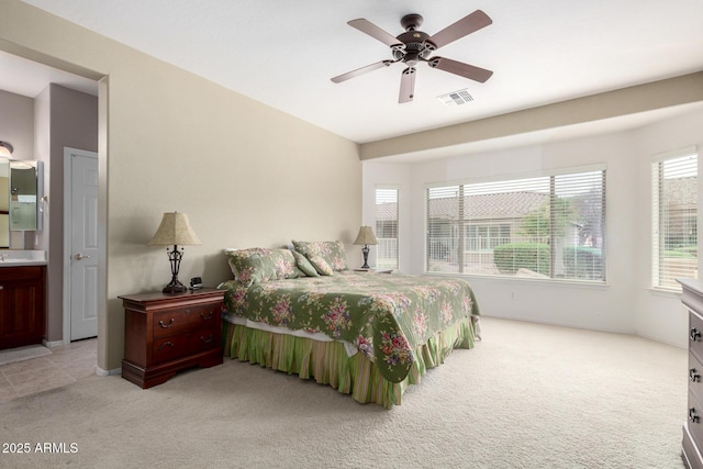 bedroom featuring a ceiling fan, light colored carpet, and visible vents