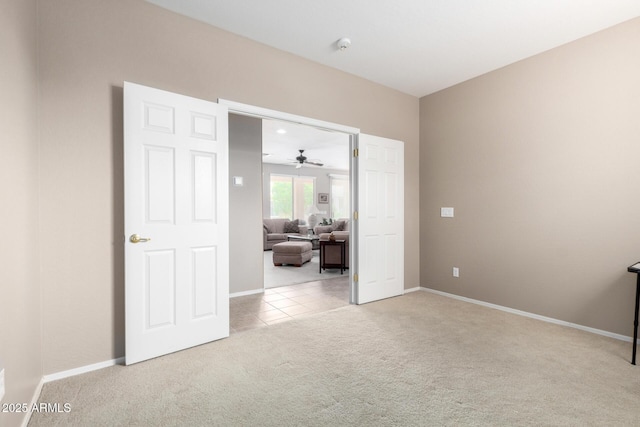 spare room with baseboards, a ceiling fan, and carpet