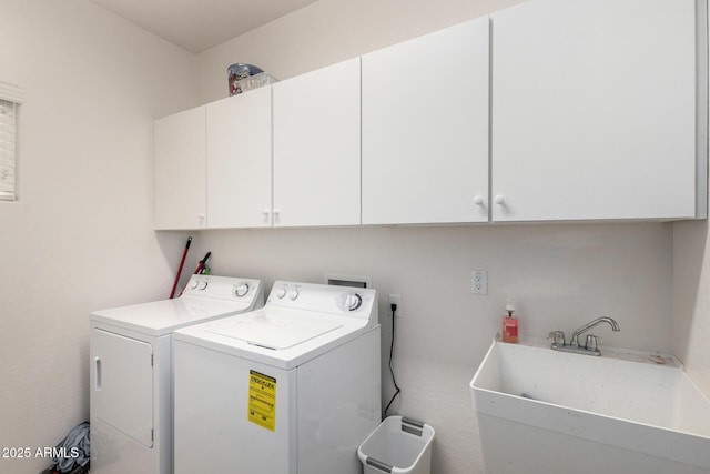 washroom with cabinet space, independent washer and dryer, and a sink