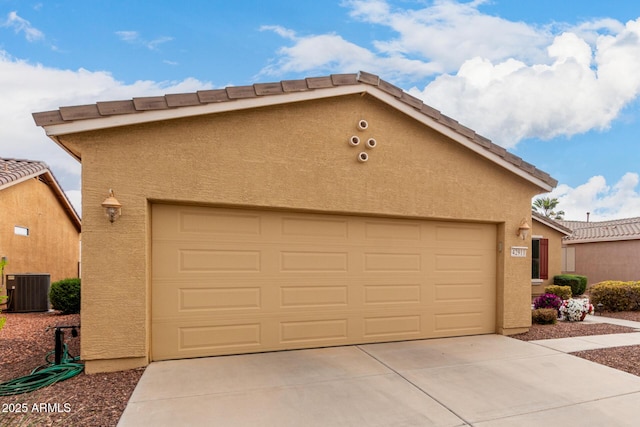 garage featuring cooling unit and driveway