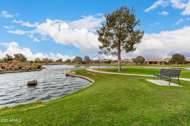 view of property's community with a yard and a water view