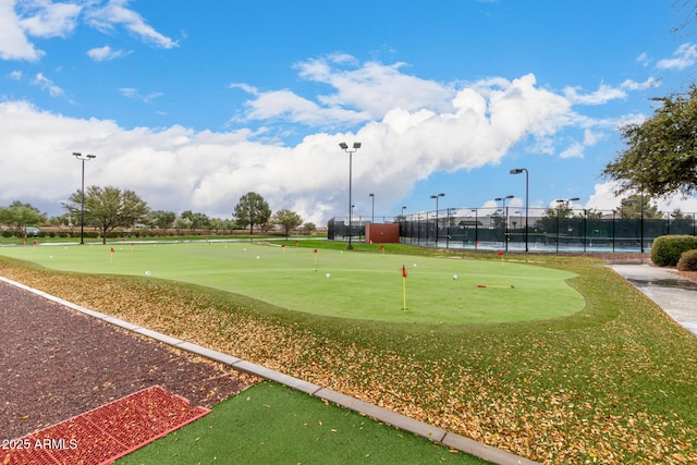 surrounding community with fence and view of golf course