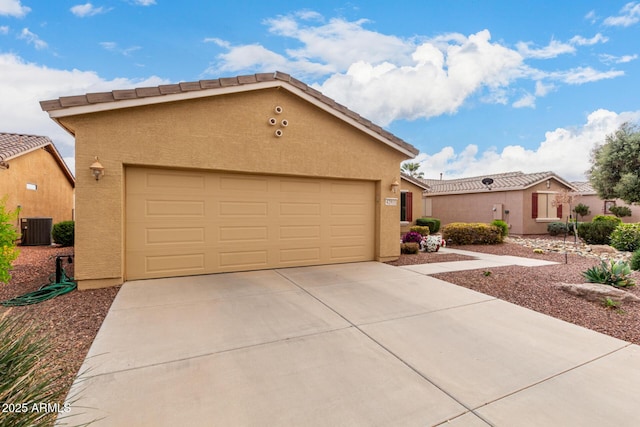 view of front of house featuring a tiled roof, concrete driveway, central air condition unit, and stucco siding