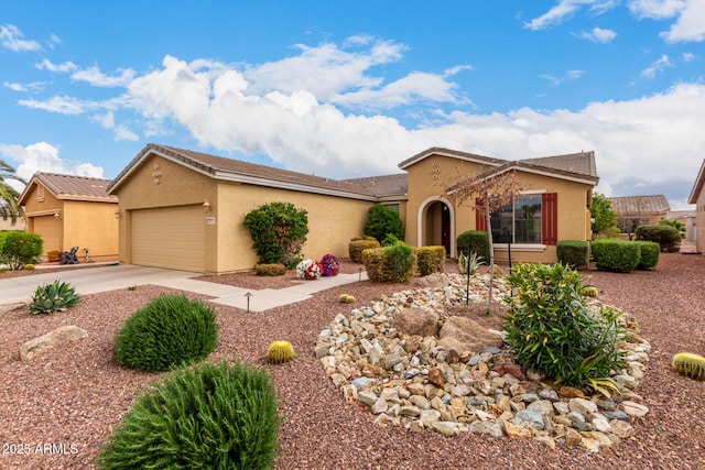 view of front of property with stucco siding, an attached garage, driveway, and a tile roof