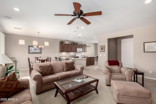 living area featuring recessed lighting, visible vents, and ceiling fan with notable chandelier