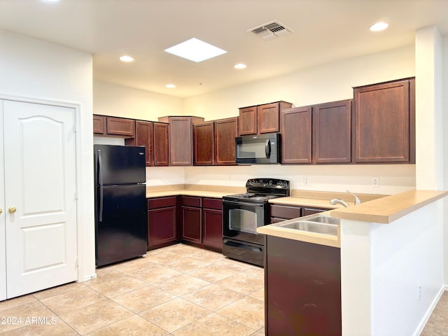 kitchen featuring kitchen peninsula, sink, light tile patterned floors, and black appliances