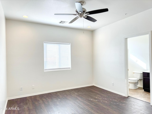 unfurnished bedroom featuring ceiling fan, dark wood-type flooring, and ensuite bath