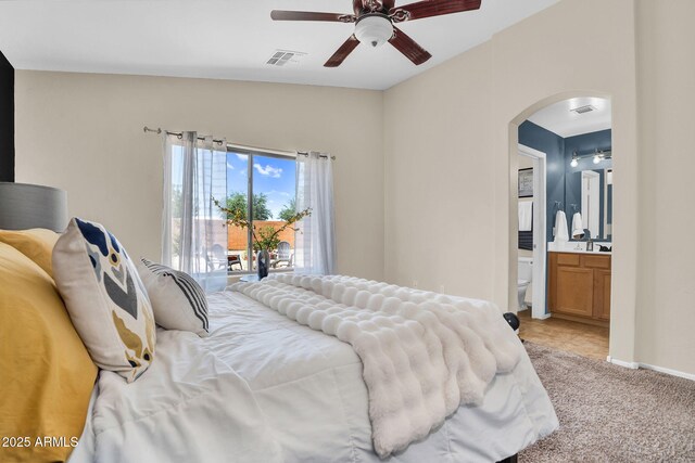 2738 E Silversmith Trl, San Tan Valley, AZ 85143 - bedroom with arched walkways, access to exterior, ensuite bath, light colored carpet, and a ceiling fan