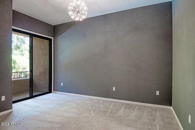 empty room with light carpet and a chandelier