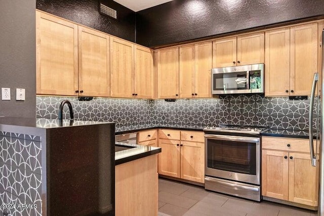 kitchen with light brown cabinets, sink, light tile patterned floors, backsplash, and appliances with stainless steel finishes