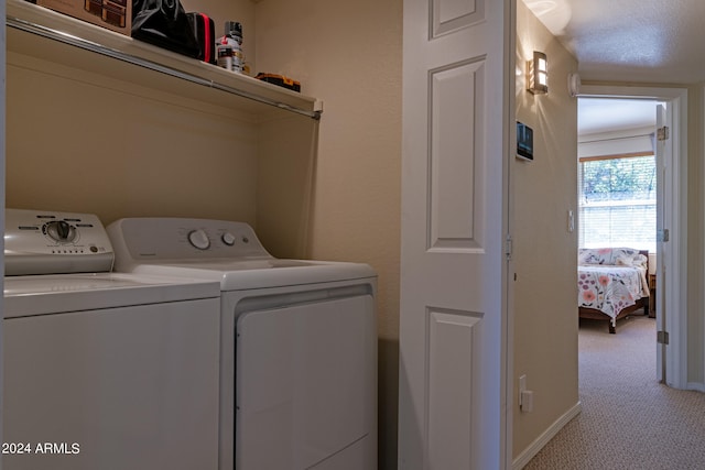 washroom featuring light carpet, a textured ceiling, and washer and dryer