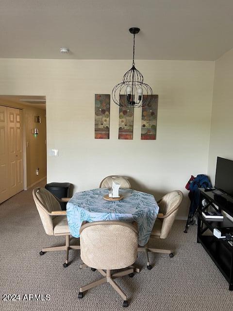 carpeted dining room featuring a chandelier