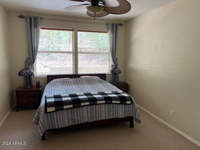 carpeted bedroom featuring multiple windows and ceiling fan