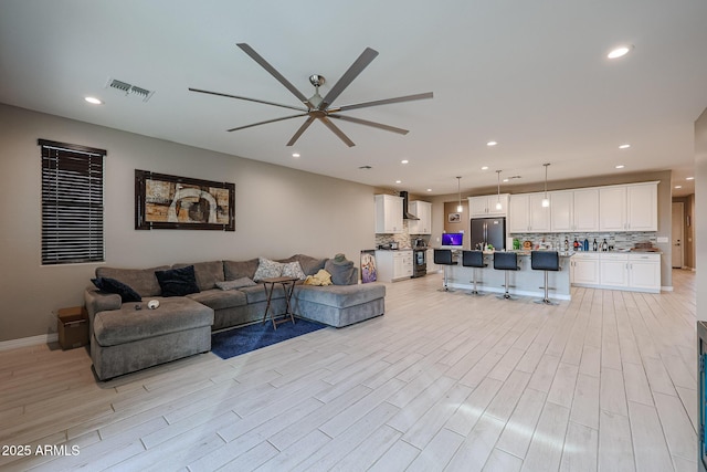 living room featuring ceiling fan and light hardwood / wood-style flooring