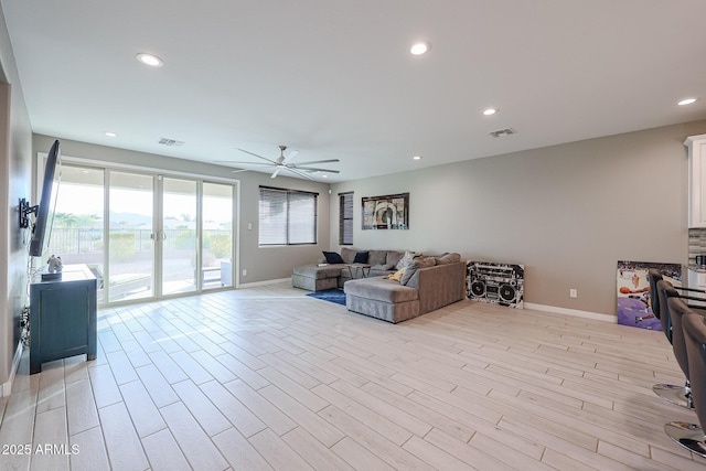 living room with light hardwood / wood-style flooring and ceiling fan