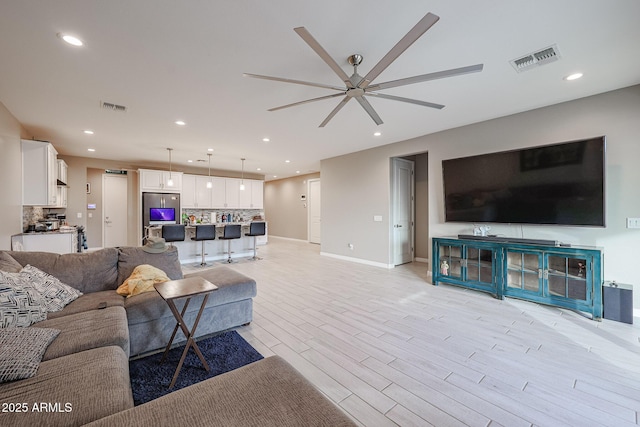 living room featuring light hardwood / wood-style flooring and ceiling fan