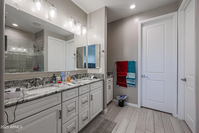 bathroom with vanity, wood-type flooring, and a shower with door